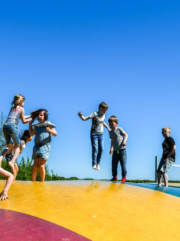 Foto van springende kinderen op onze air-trampoline op Camping Ikeleane